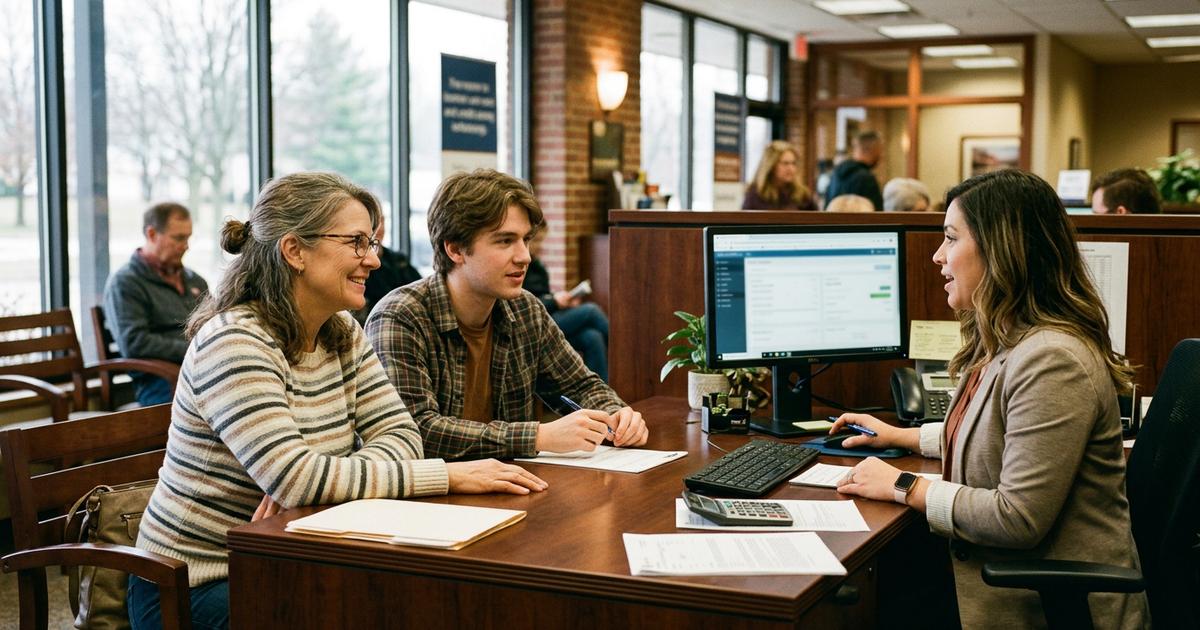 A mother and her adult son opening an account together at a credit union desk